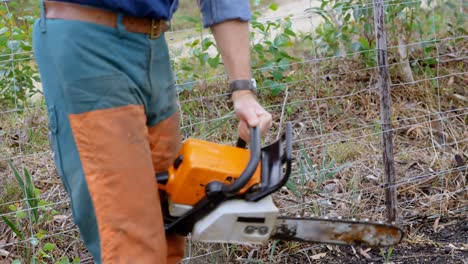 Lumberjack-using-electric-saw-in-the-forest-4k