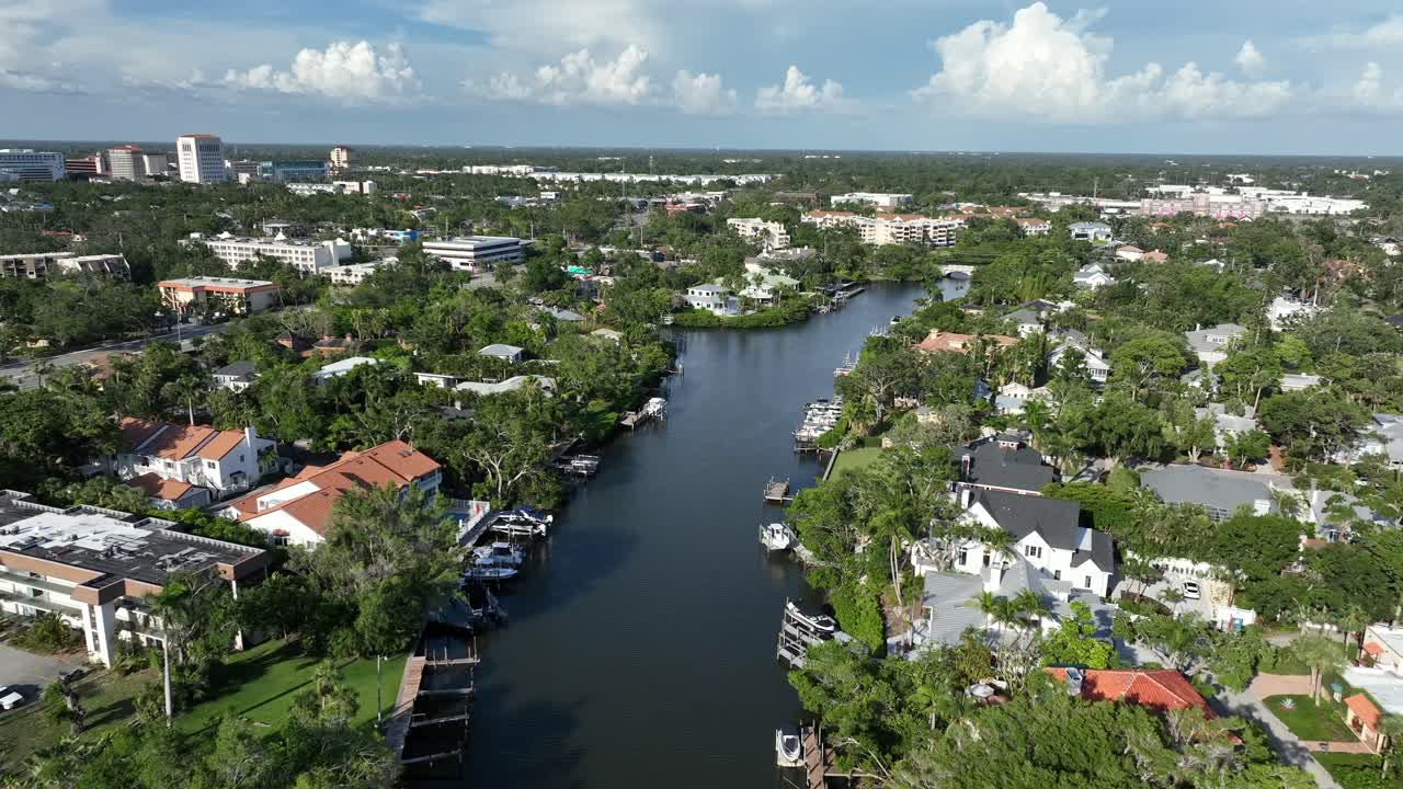Luyury neighborhood with private river access and pier jetty with parking boats in Florida. Aerial flyover shot. Sarasota city residential area in upper class district. Sunny day in summer.