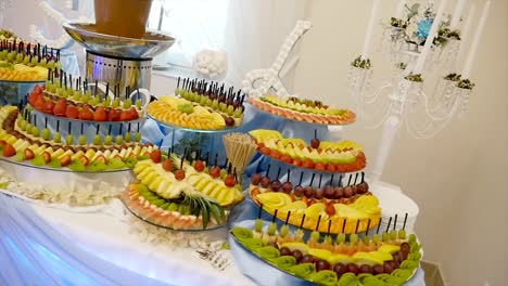 diferentes frutas frescas en la mesa de buffet de boda. frutas y bayas decoración de mesa de boda. recepción de buffet vinos de frutas champaña decoración de tabla de boda