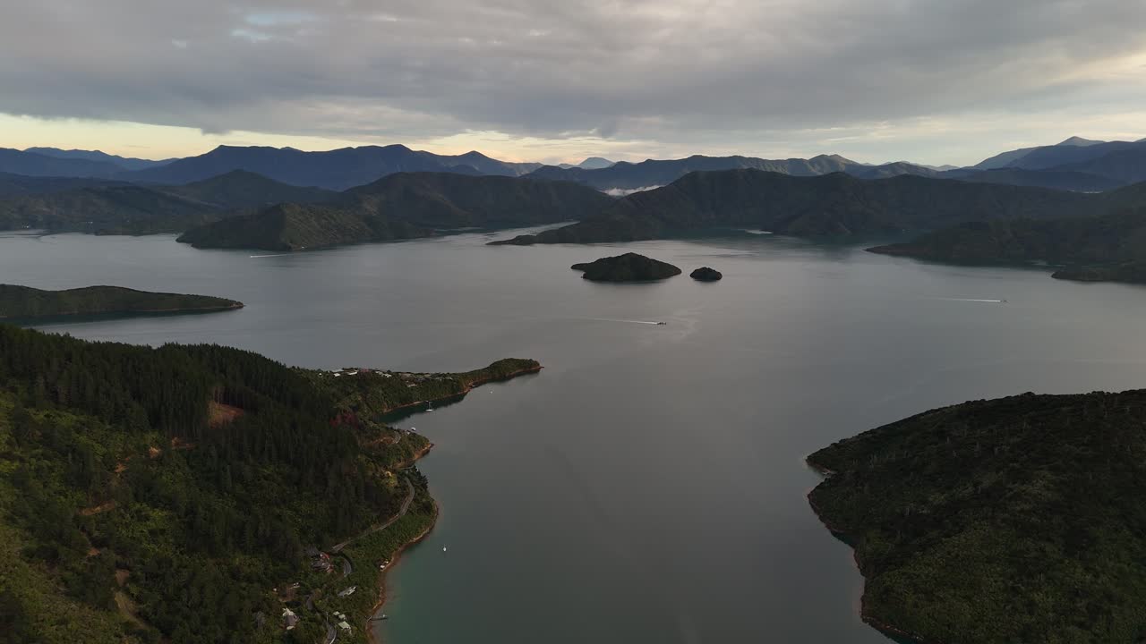 Panoramic aerial drone view of Cook Strait, separating North and South Islands of New Zealand, with rugged mountains and vast water under a cloudy sky. Epic landscape