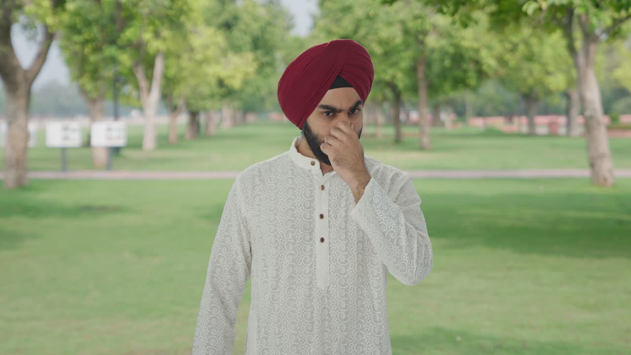 Uomo sikh indiano disgustato e frustrato per il cattivo odore nel parco