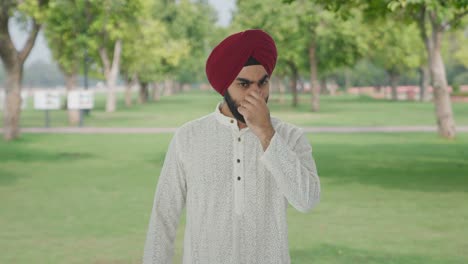 disgusted sikh indian man frustrated by bad smell in park