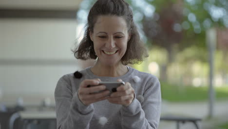 Emotional-middle-aged-woman-using-smartphone-outdoor.