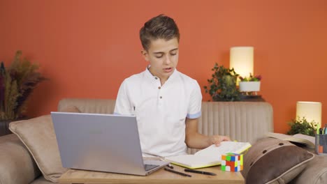 boy studying on laptop chatting facetime.