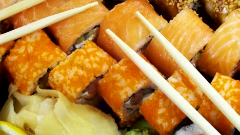los rollos de sushi japoneses con palillos giran
