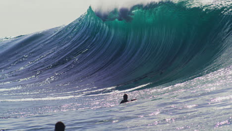 Gran-Ola-Azul-Del-Océano-Pacífico-Lanza-El-Labio-Hacia-Adelante-Sobre-Los-Surfistas-Con-Un-Color-Verde-Brillante