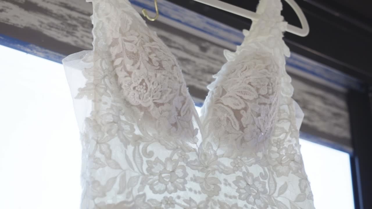 을 는 웨딩 드레스가 결혼식 전에 매달려 있습니다.