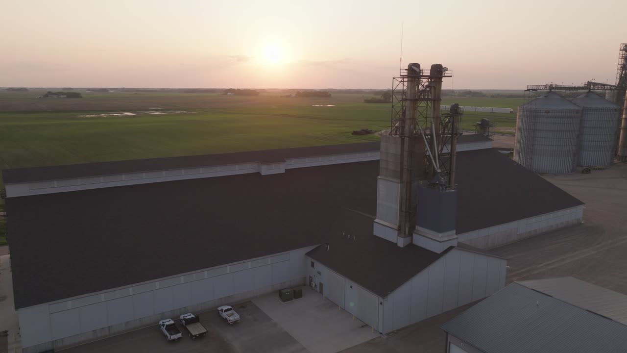 Aerial View Of Fertilizer Plant Overlooking The Bright Sun At Sunset And Countryside Fields For Growing Crops