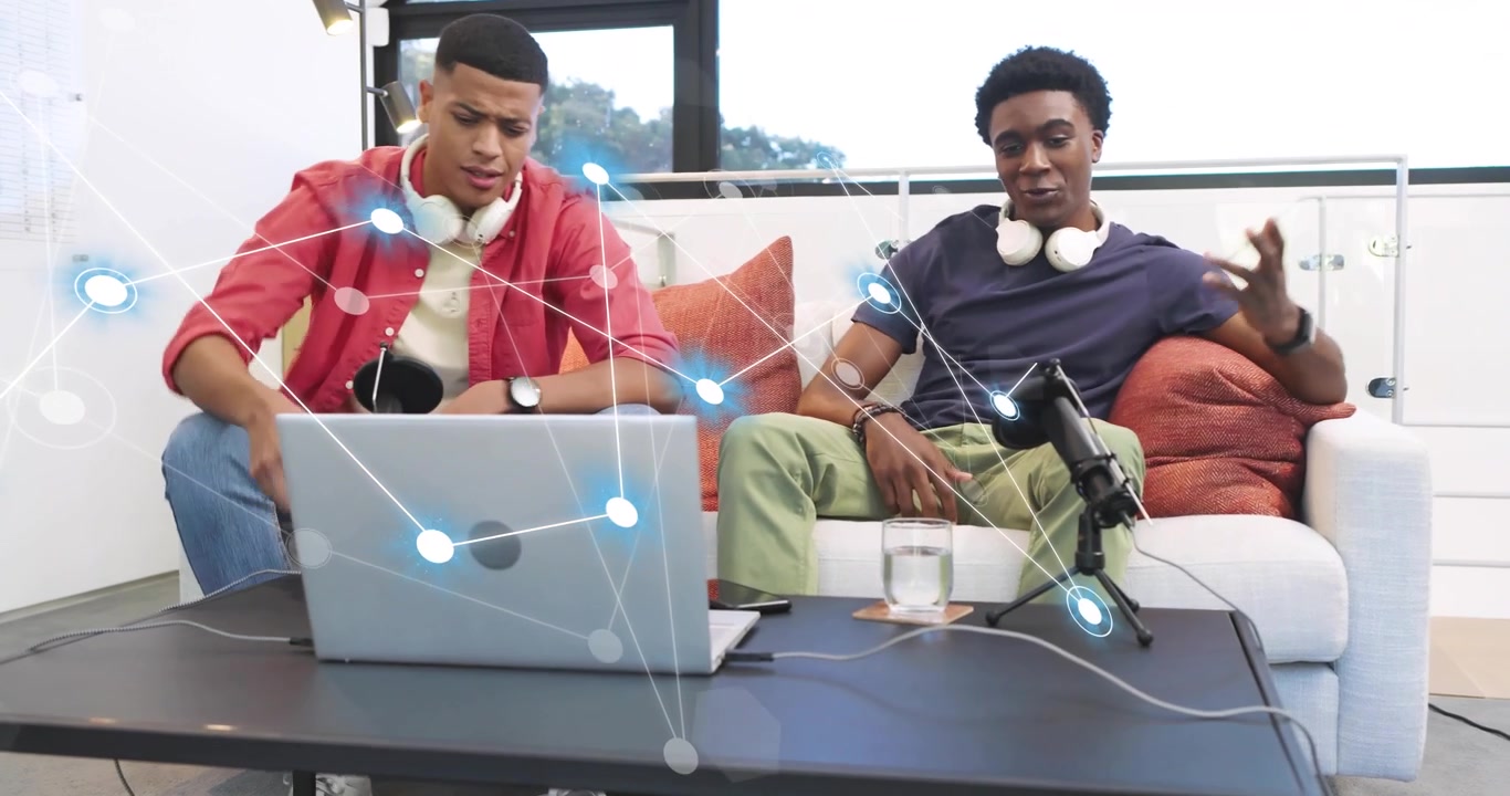 Network overlay appearing as hosts gesturing at laptop, sipping water, laughing in tech discussion