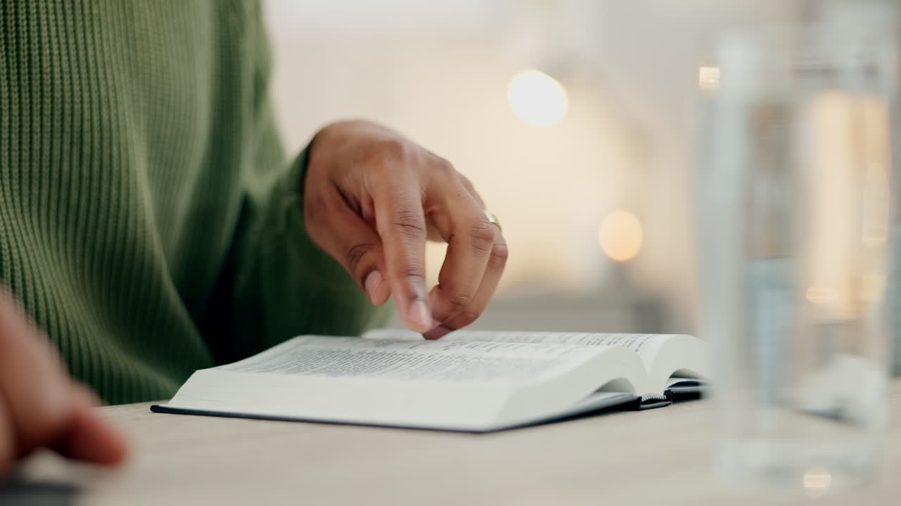 Hands, reading bible and closeup at desk