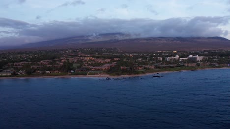 Low-aerial-dolly-shot-across-the-luxury-beach-resorts-of-Wailea-at-the-foot-of-Haleakala-during-sunset-in-South-Maui,-Hawai'i