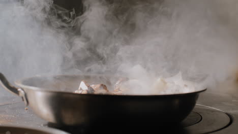 mushrooms being sautéed in a hot pan