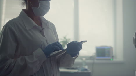 Woman-physician-typing-health-complaint-on-tablet-closeup.-Nurse-testing-patient