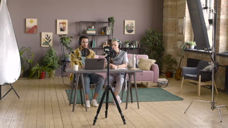 Camera-Is-Recording-A-Woman-And-Man-Sitting-At-Table-While-Doing-A-Podcast-2