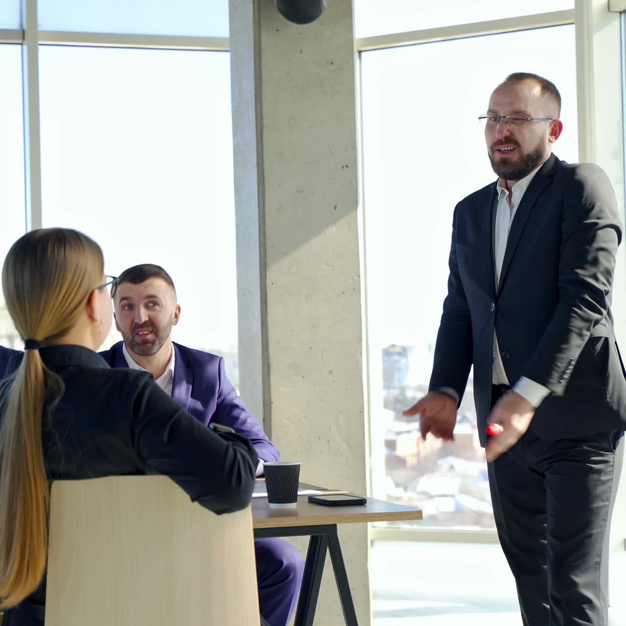 Uomo d'affari maturo che condivide le sue nuove idee con i colleghi. Partner commerciali che discutono di lavoro insieme in ufficio mentre ascoltano un uomo d'affari di successo