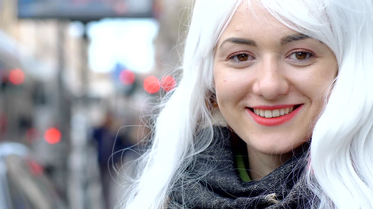 una joven sonriente y graciosa con una perla blanca en la calle.