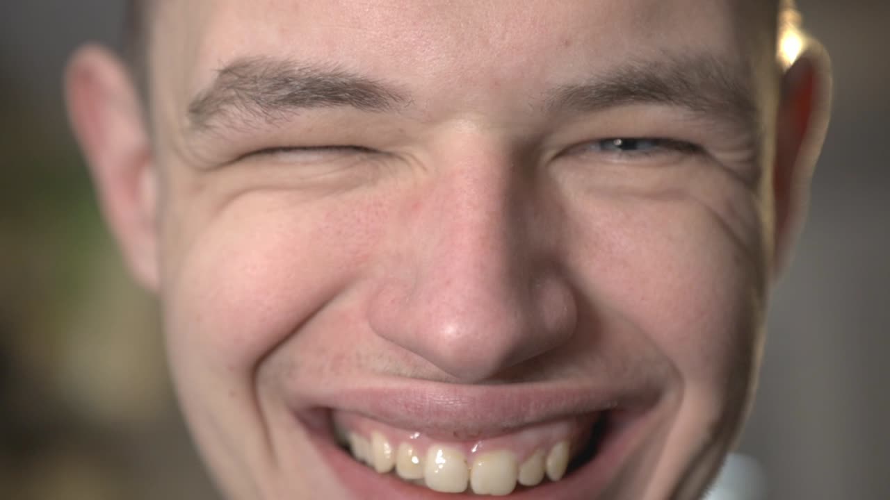 A Happy Man's Face Showing His Teeth While Smiling - Closeup Shot