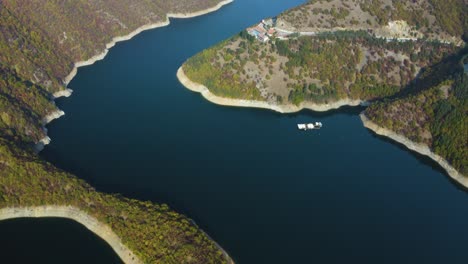 Aerial-pan-up-over-beautiful-mountain-lake-and-hotel-resort-with-pool