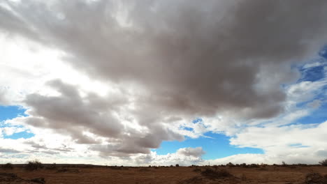 the sun and clouds move quickly over the featureless mojave desert in this long duration time lapse