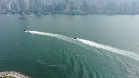 Hong-Kong-coastguard-boats-roaring-across-the-open-bay-waters,-Aerial-view