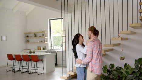 a young biracial couple shares playful moment in a modern kitchen, copy space