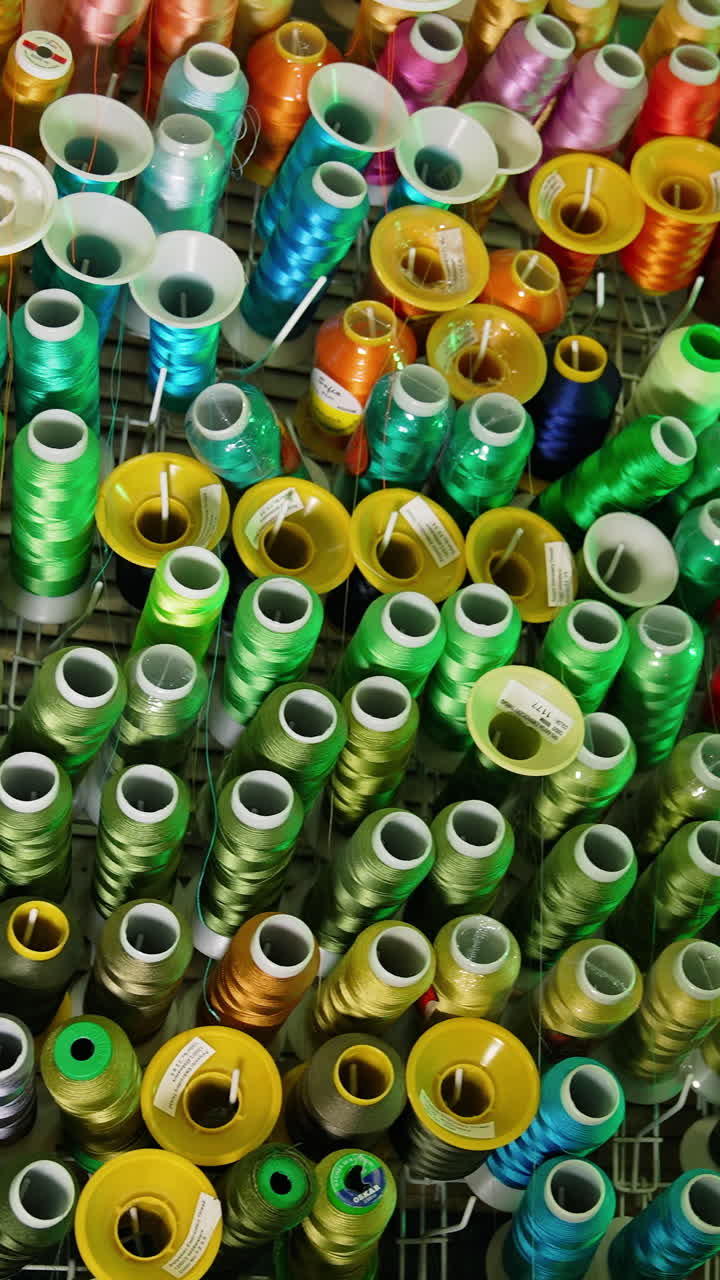 Colorful sewing threads background. Many spools of thread of different colors. Sewing tools. Hobbies and handicrafts. Vertical video