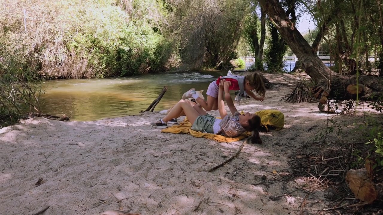 Mother and Daughter Playing Together on a Riverbank