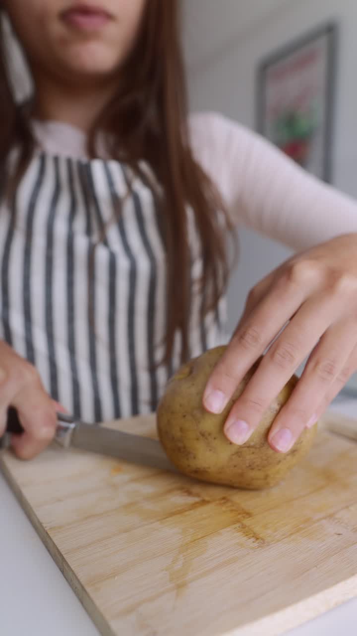 Woman cutting a potato