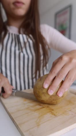woman cutting a potato