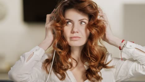 happy woman putting earphones on head at living room.