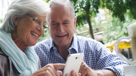 Senior-couple-discussing-over-the-phone-in-the-cafe-4k