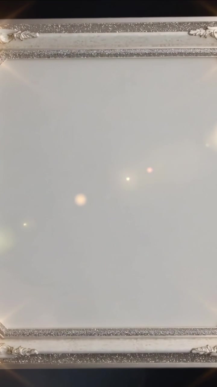Video verticale: Telecamera che scorre verso il basso su una cornice ornata in una stanza, rivelando un bokeh caldo su un pannello vuoto