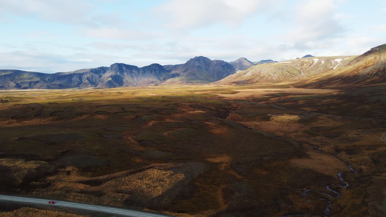 una foto aérea de la hermosa campiña islandesa con grandes montañas en la distancia en un día soleado