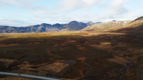 una foto aérea de la hermosa campiña islandesa con grandes montañas en la distancia en un día soleado