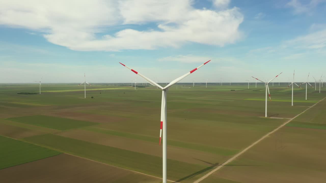 View of several windmills, wind generators, turbines, producing renewable clean energy by converting kinetic energy