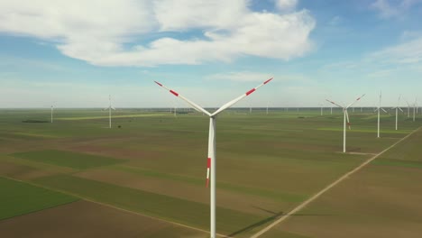 view of several windmills, wind generators, turbines, producing renewable clean energy by converting kinetic energy