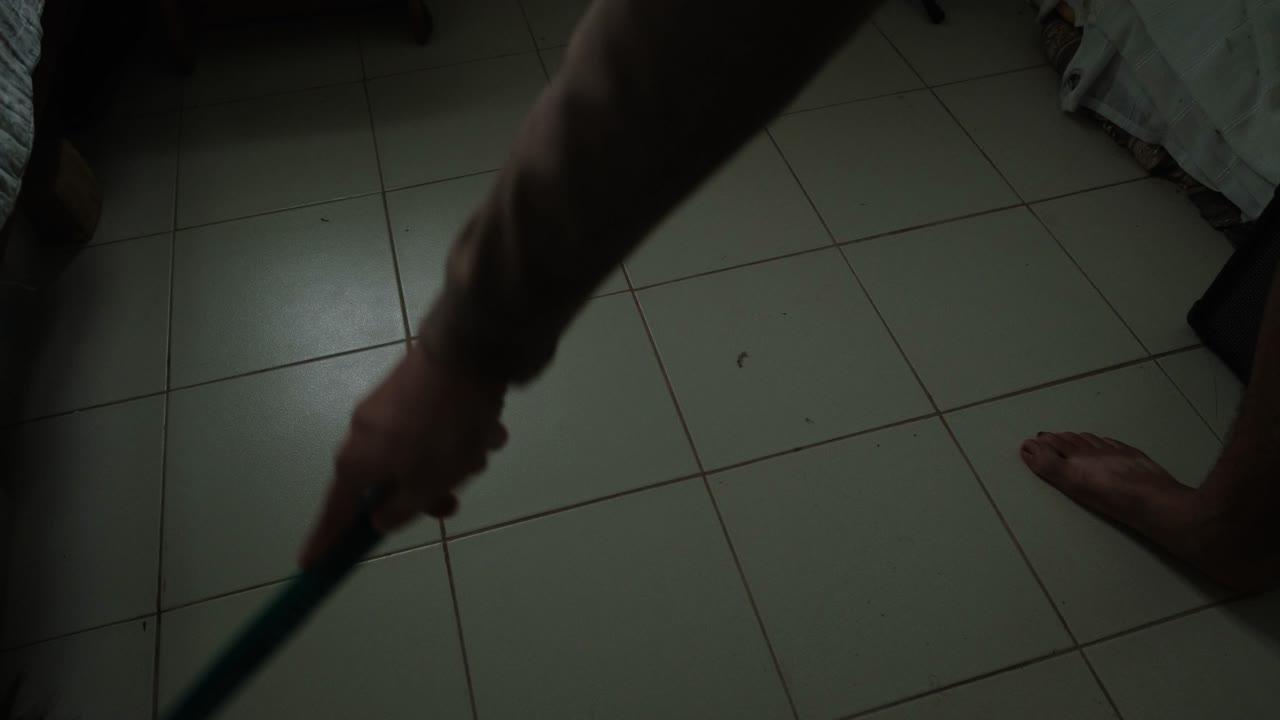 High angle wide view of traditional Filipino broom sweeping floor in Asian household.