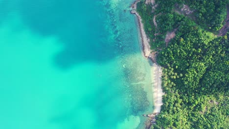 Wolken-Werfen-Schatten-über-Das-Türkisfarbene-Ruhige-Meer-Mit-Sandiger-Küste-Und-Palmenplantage-Am-Inselrand