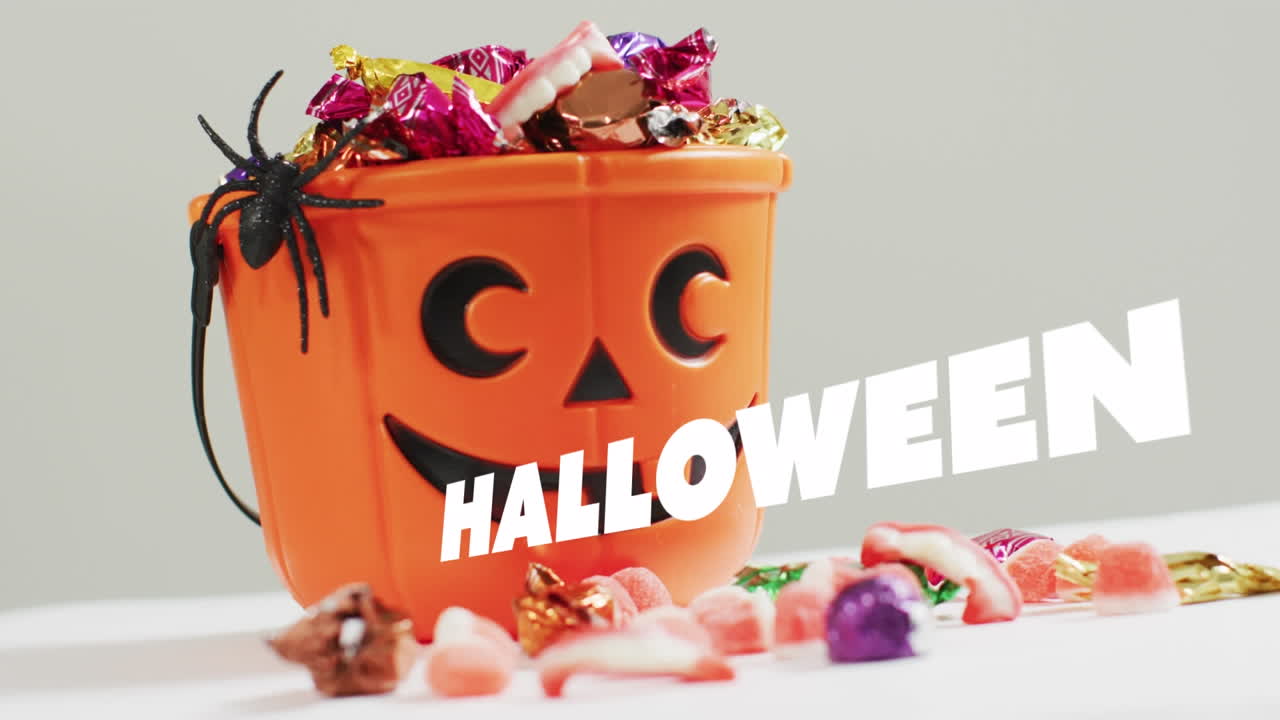 회색 배경에 과자와 함께 조각 된 호박 버 ⁇  위에 할로윈 텍스트의 애니메이션