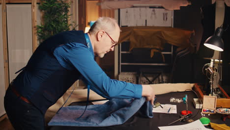 male tailor using fabric for needlework