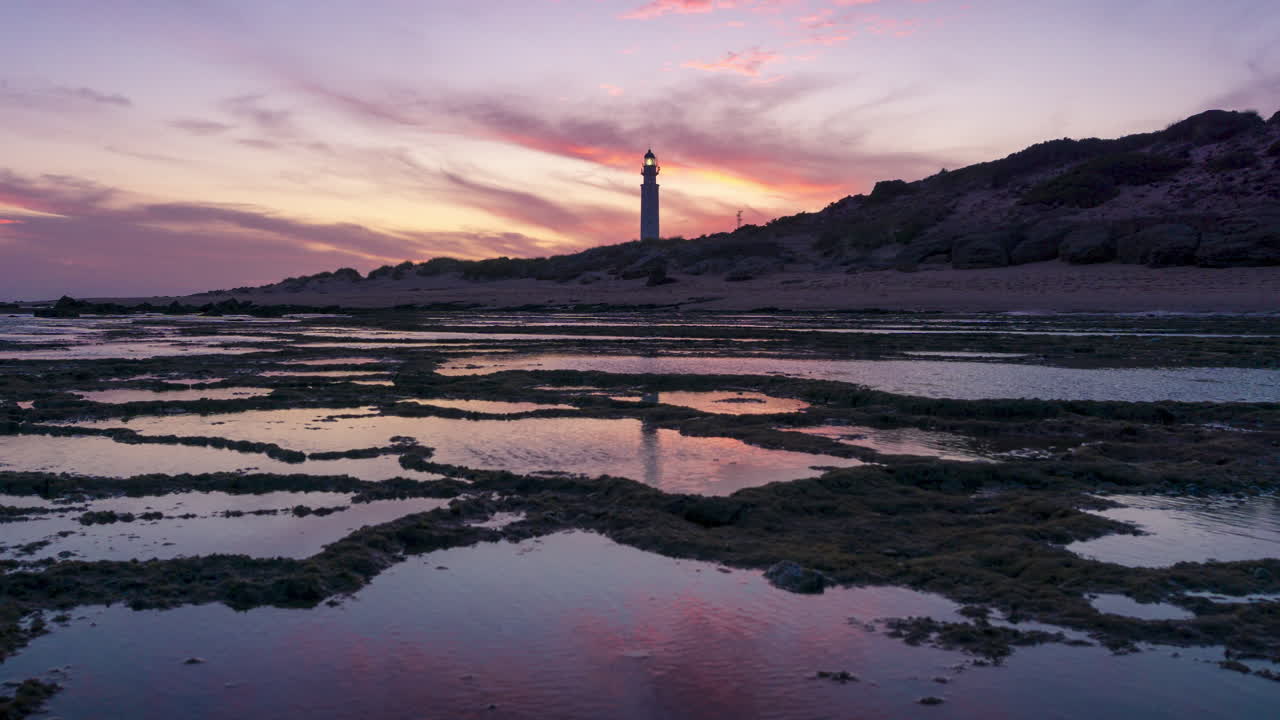 hermoso y colorido lapso de tiempo de la puesta de sol en el faro de faro de trafalgar, cádiz, españa
