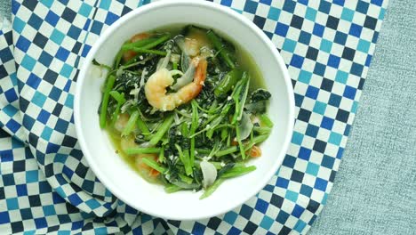 top view of bowl with cooked spinach on table