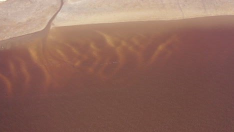 a top down shot over a shallow brown creek during the day