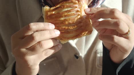 person eating a cheese pastry