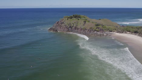 aerial view of norries headland and surfers on the ocean in cabarita beach, new south wales, australia - drone shot