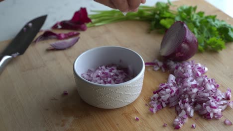 recoger cebollas rojas picadas y agregarlas en un cuenco e ingredientes especiales para cocinar una comida dos latas de frijoles arroz plátano aguacate cebolla roja y cilantro