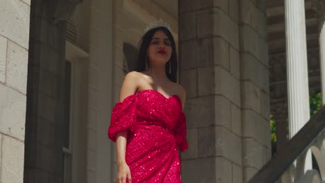 dentro de los enigmáticos límites de un castillo caribeño, el vestido rojo de una joven se convierte en un símbolo de elegancia atemporal.