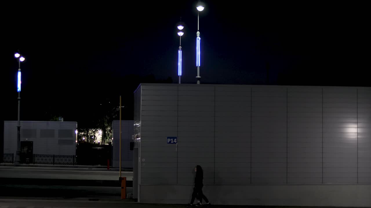 escena nocturna de un garaje de estacionamiento con un peatón