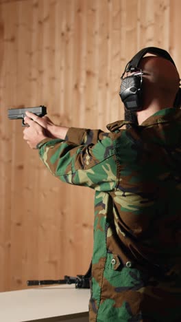 vertical video joyous soldier training with firearm exults after accurately hitting bullseye