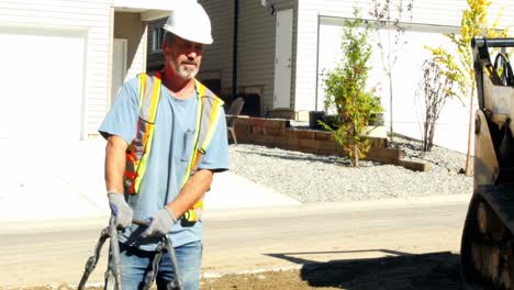 Worker-with-soil-compactors